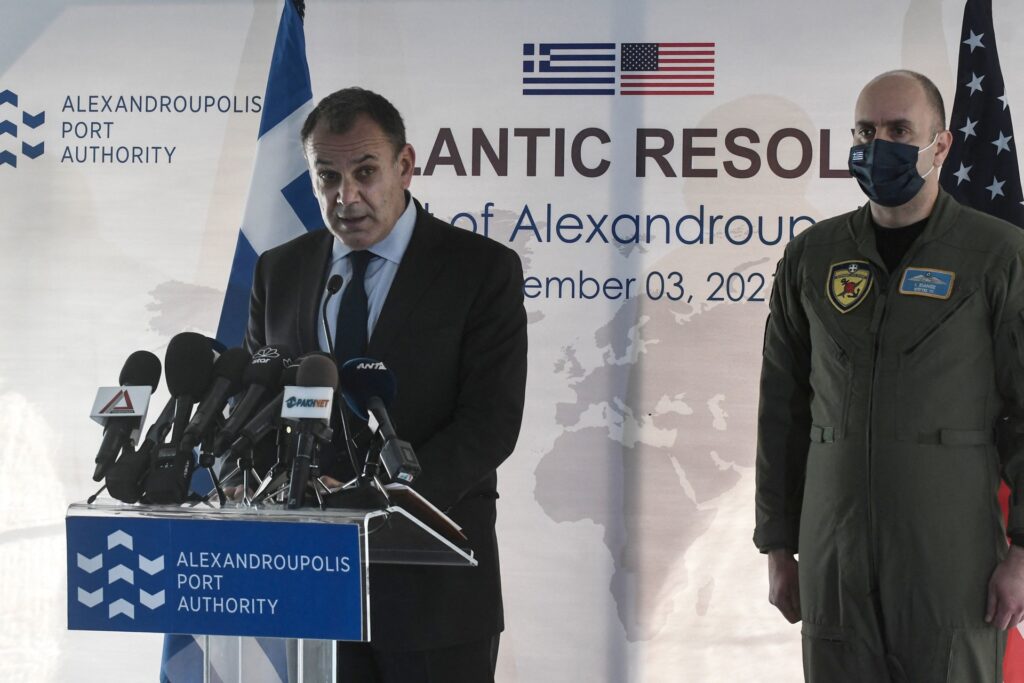 Greece's Minister of Defence Nikolaos Panagiotopoulos (C) delivers a speech during a ceremony in the port of Alexandroupoli, Northern Greece, on December 3, 2021. - A large number of helicopters, unmanned aerial vehicles (UAVs), tanks, cannon, and artillery have reached the Greek port near the border with Turkey as part of an extensive military shipment that is of an unprecedented scale as envisaged by the recently signed bilateral Mutual Defense and Cooperation Agreement. (Sakis Mitrolidis / AFP via Getty Images)