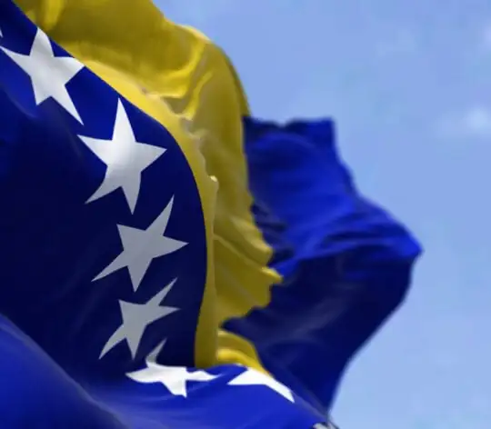 Detail of the national flag of Bosnia and Herzegovina waving in the wind on a clear day.