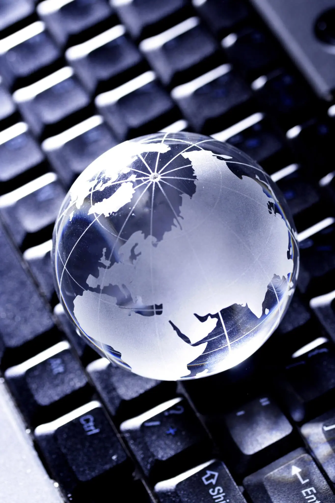 Glass globe on computer keyboard