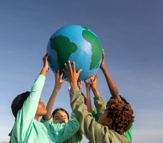 Group of children working together to hold up the world