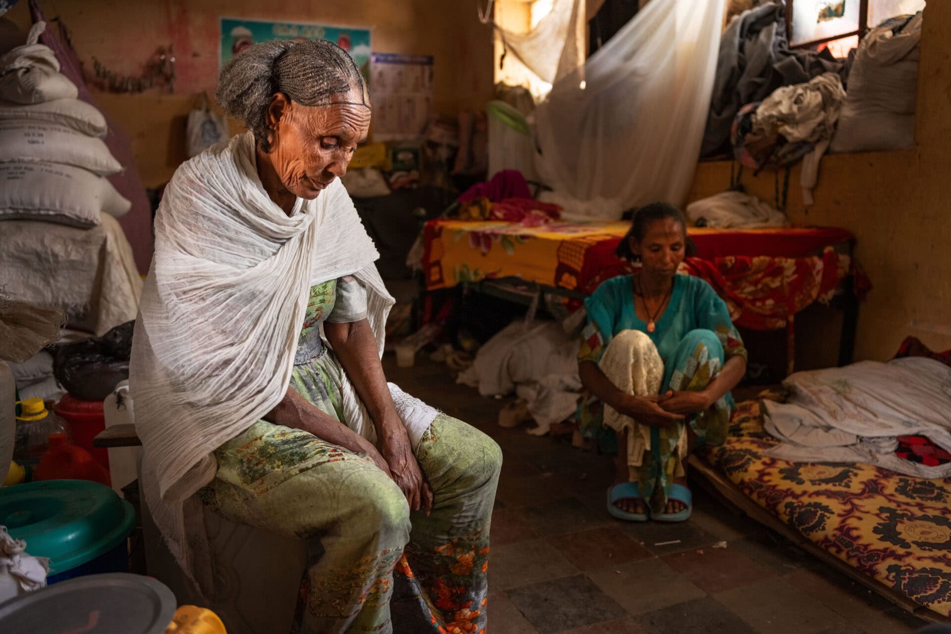 Refugee women sit in a room at a refugee camp in the town of