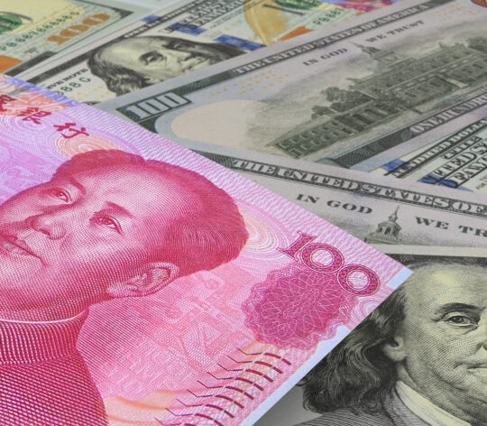 Chinese Yuan banknotes with US dollars in the background. Cash. Financial concept.