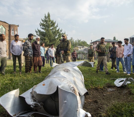 People look at a part of an unknown crashed aircraft in